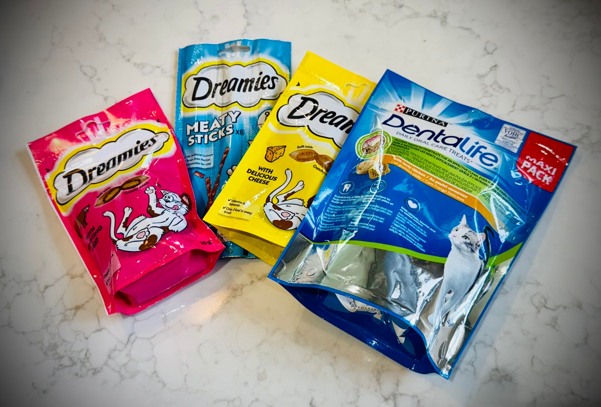 Assorted cat treats and toys with Dreamies packaging in a gift box with a handwritten card £30