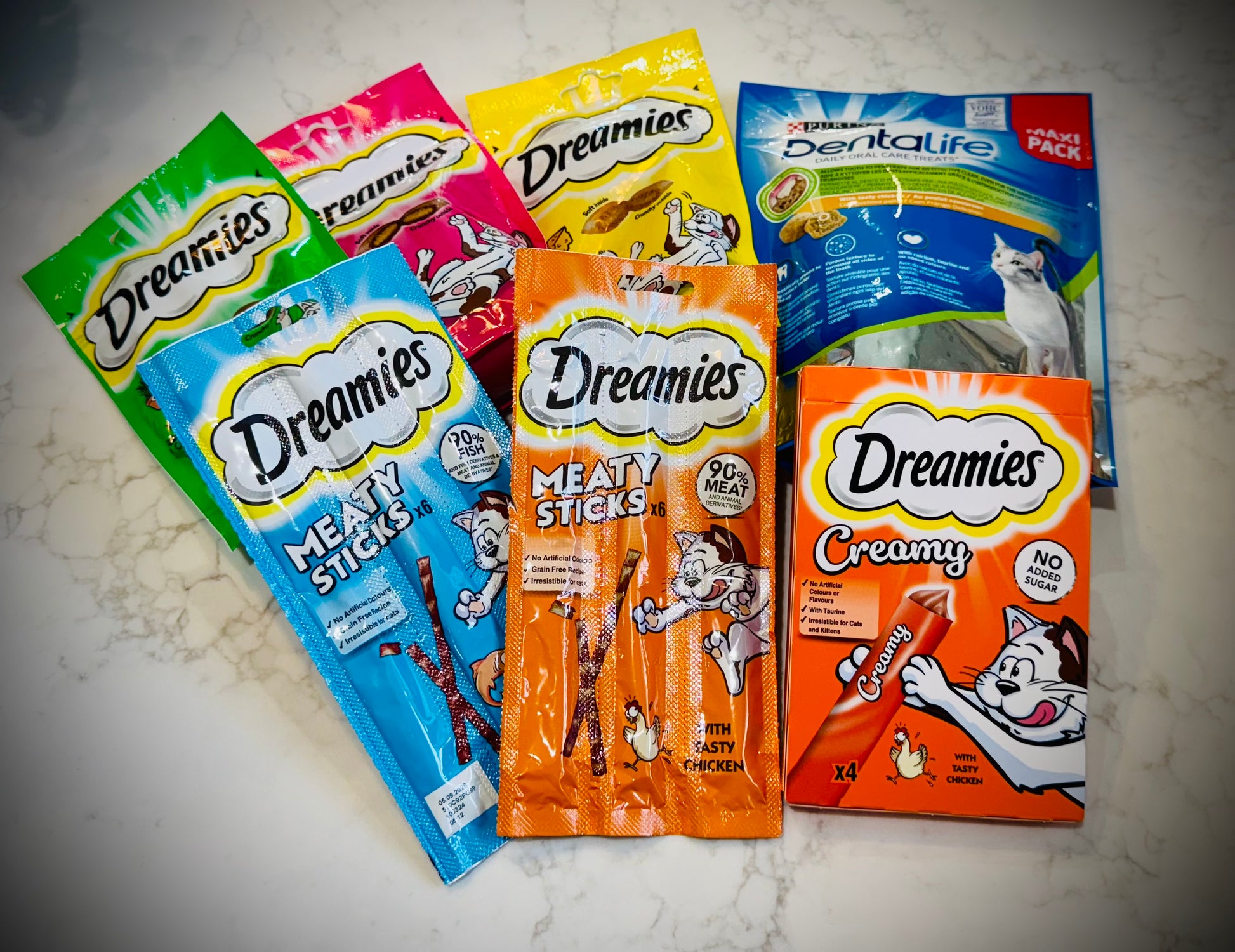 Assorted cat treats and toys with Dreamies packaging in a gift box with a handwritten card £50
