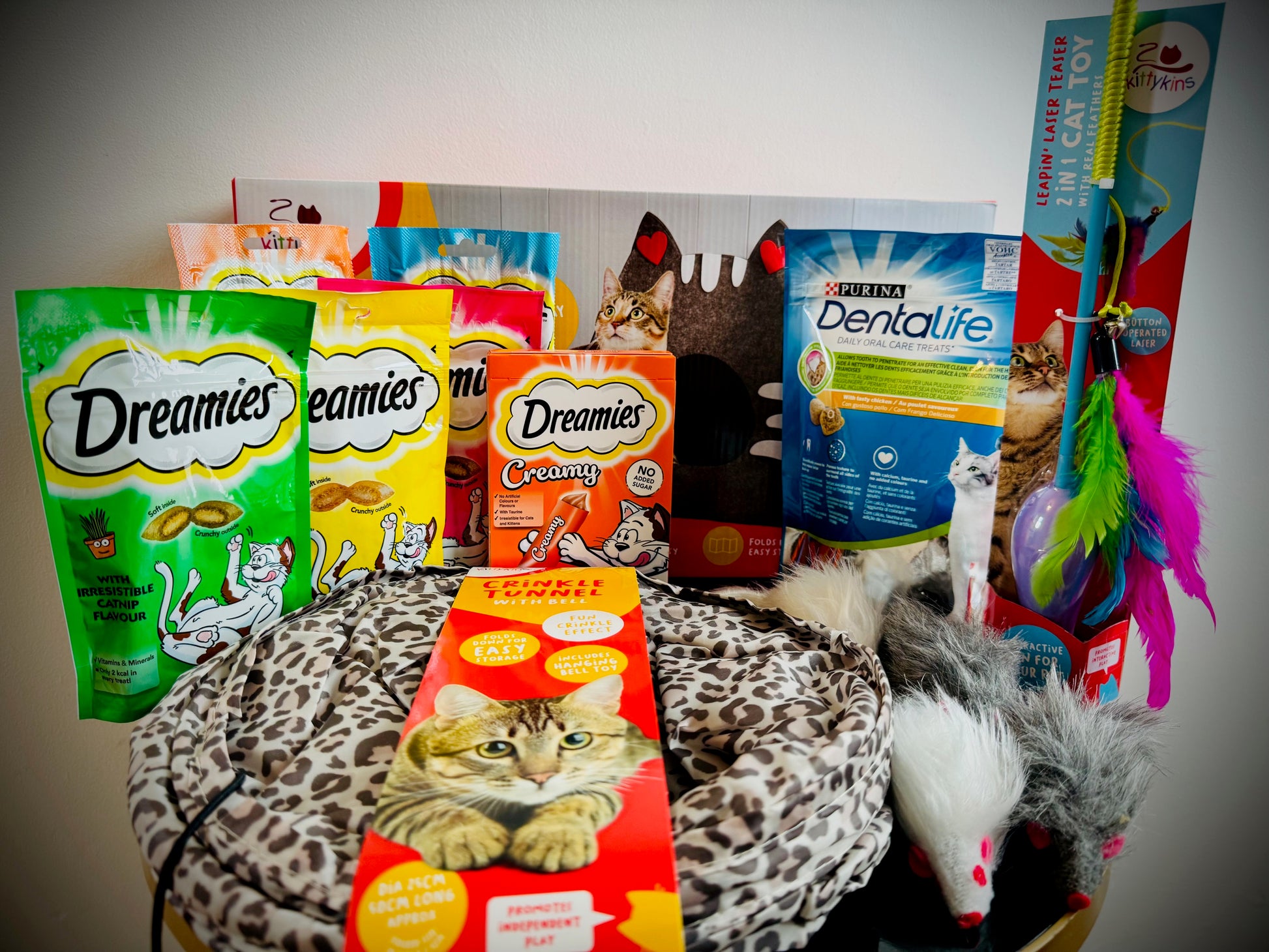 Assorted cat treats and toys with Dreamies packaging in a gift box with a handwritten card £50