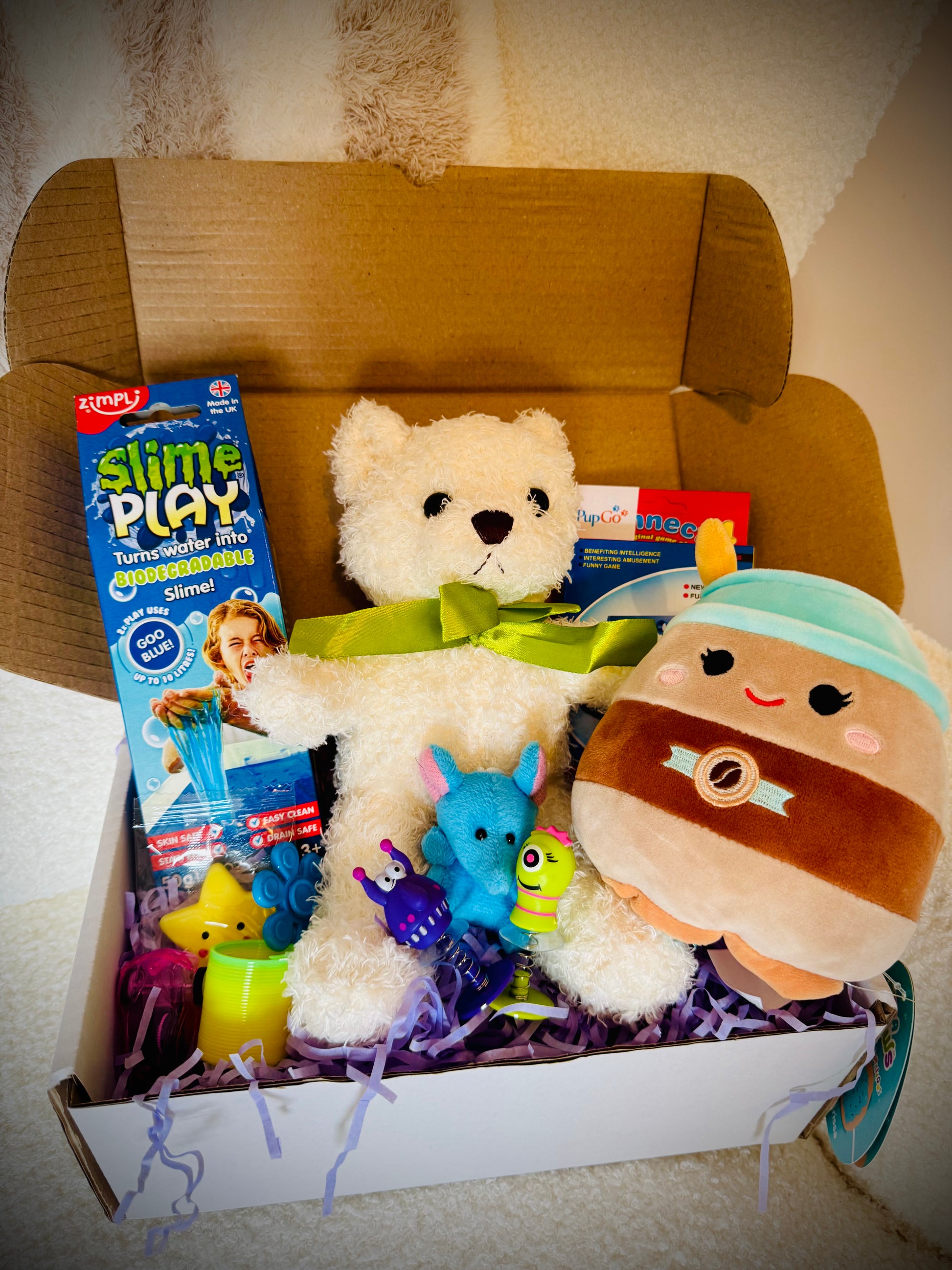 A selection of kids toys in a gift box with a handwritten card £30