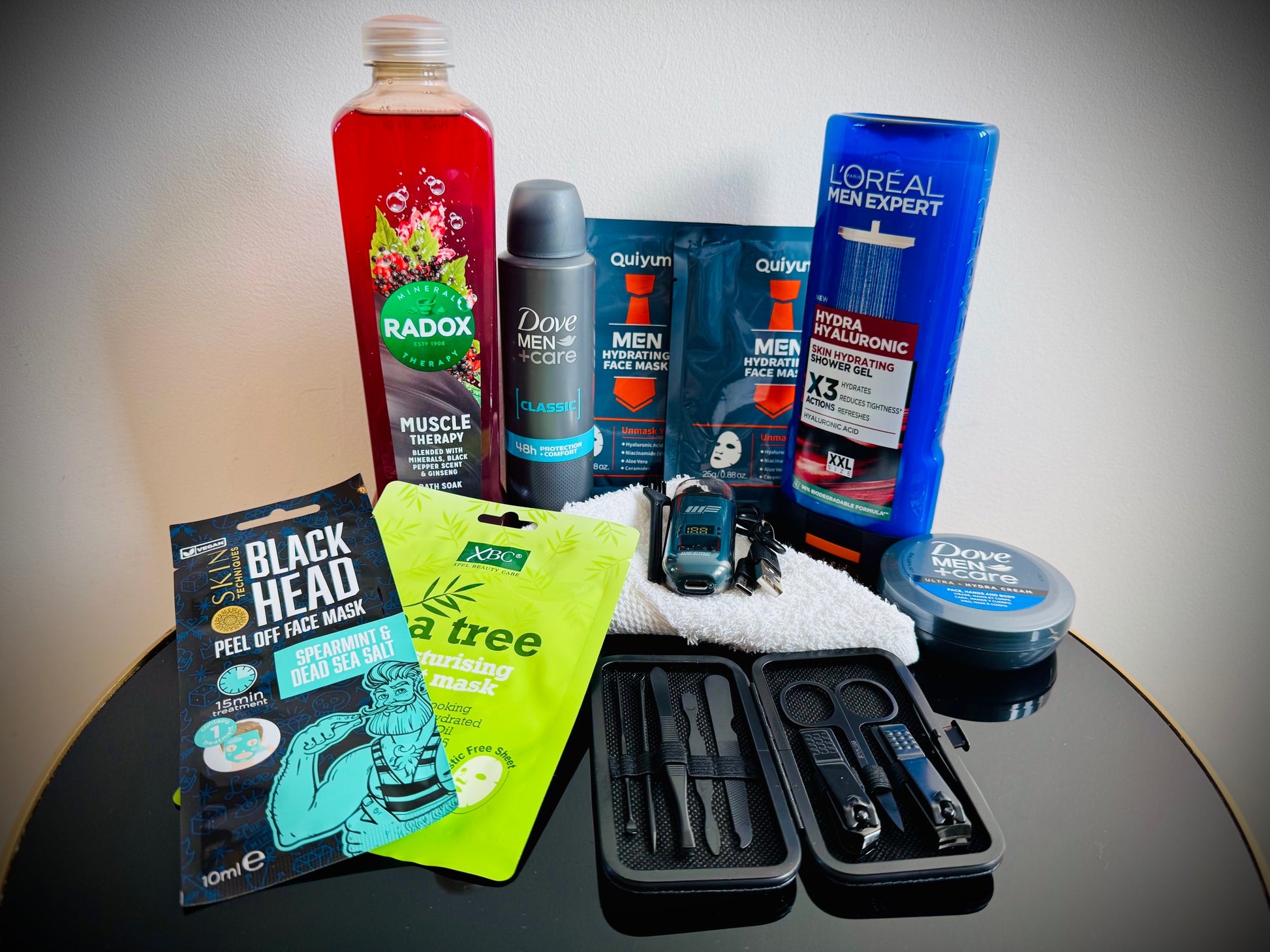 Collection of men's grooming products including face masks, soap, and lotion in a gift box with a handwritten card £30