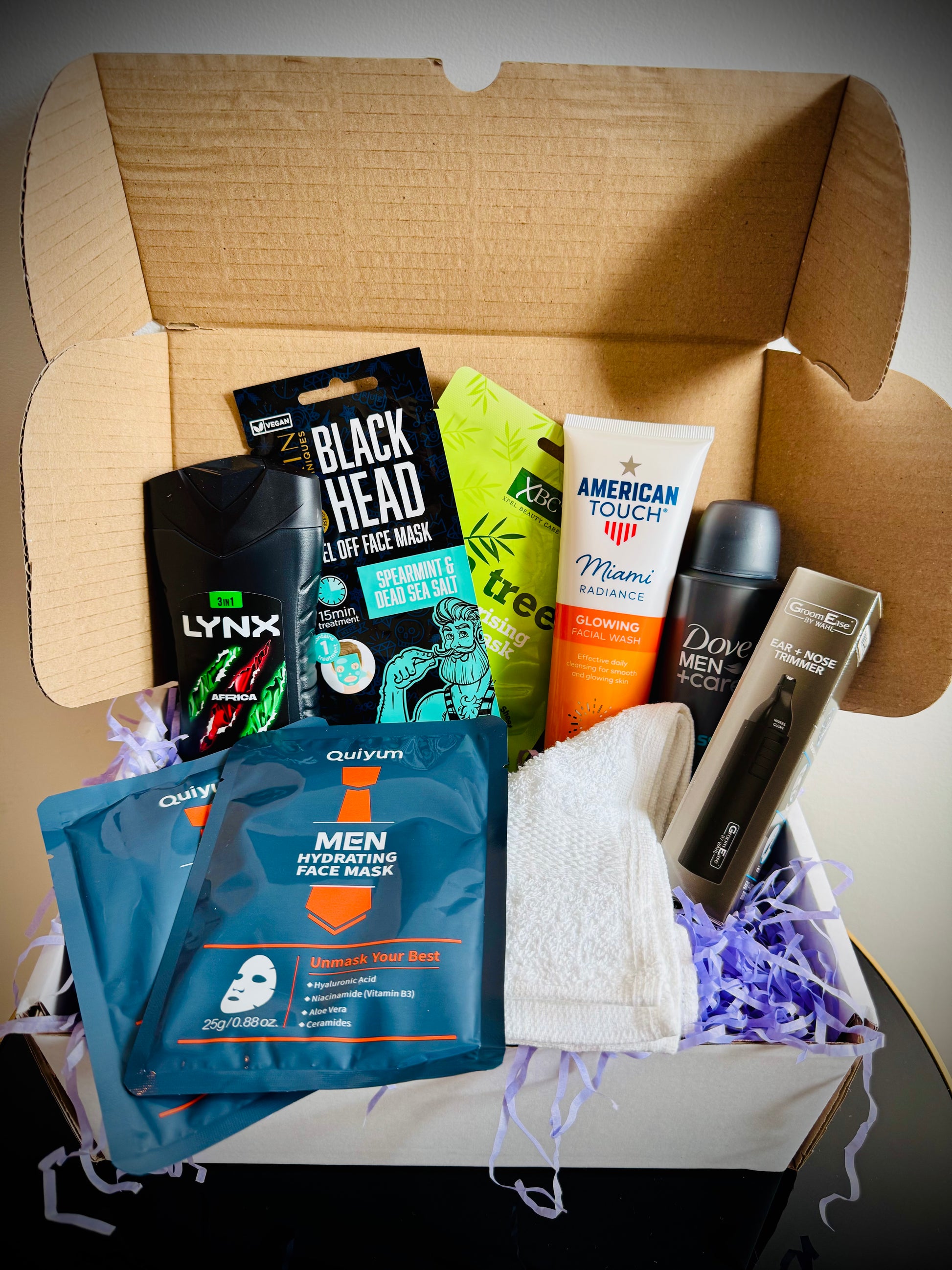 Collection of men's grooming products including face masks, soap, and lotion in a gift box with a handwritten card £20