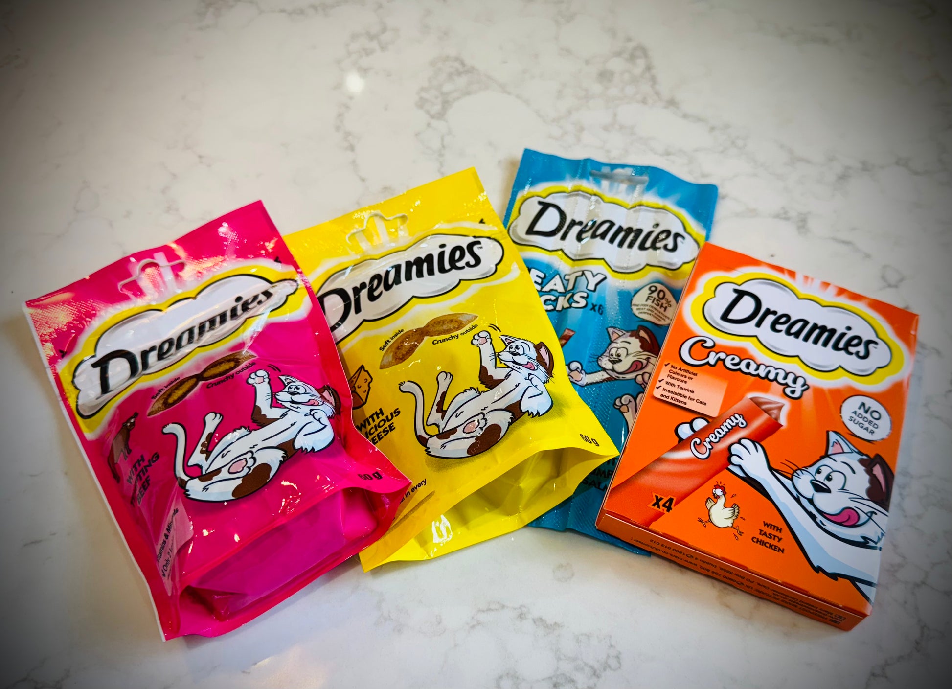 Assorted cat treats and toys with Dreamies packaging in a gift box with a handwritten card £20