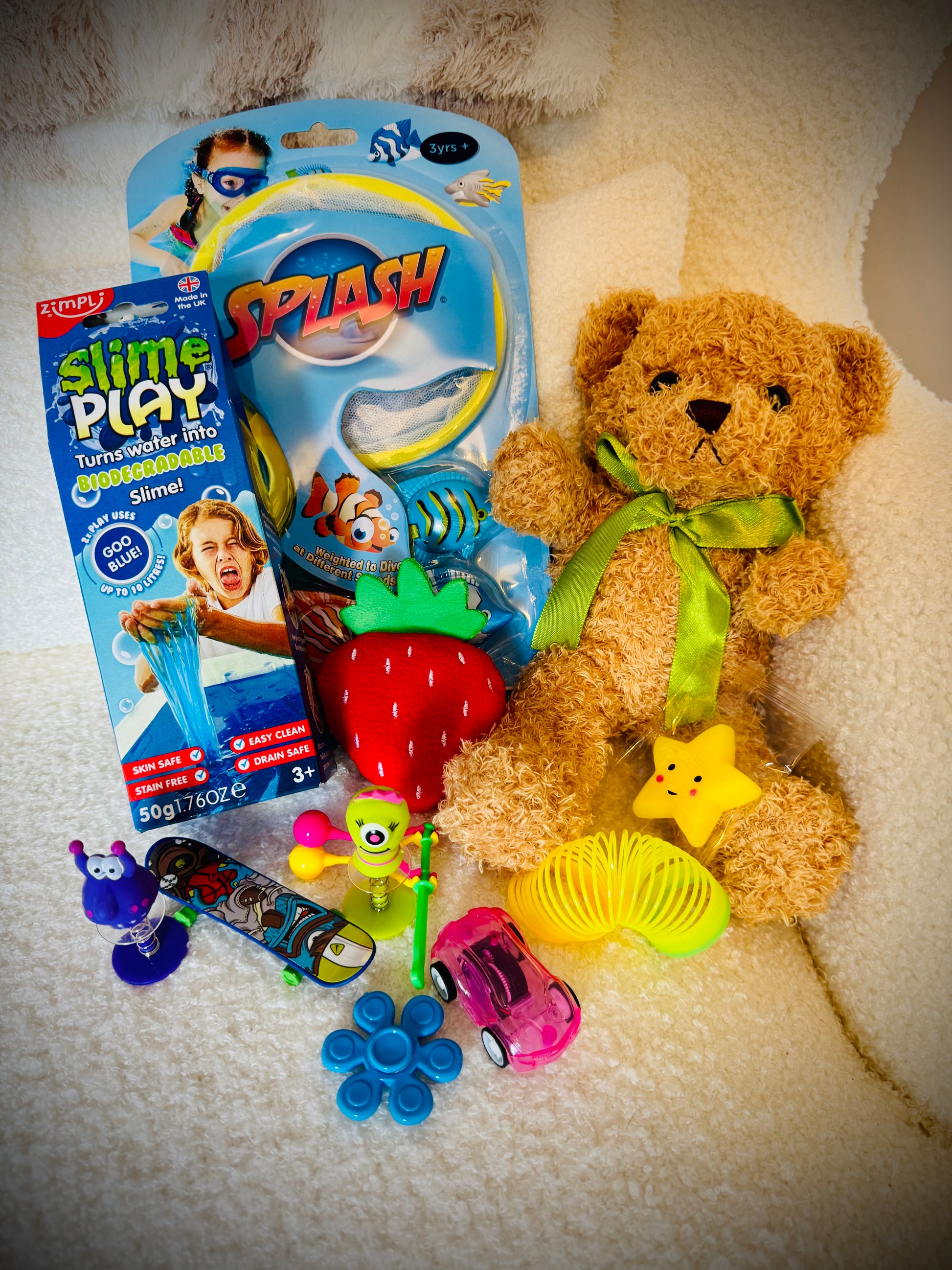 A selection of kids toys in a gift box with a handwritten card £20