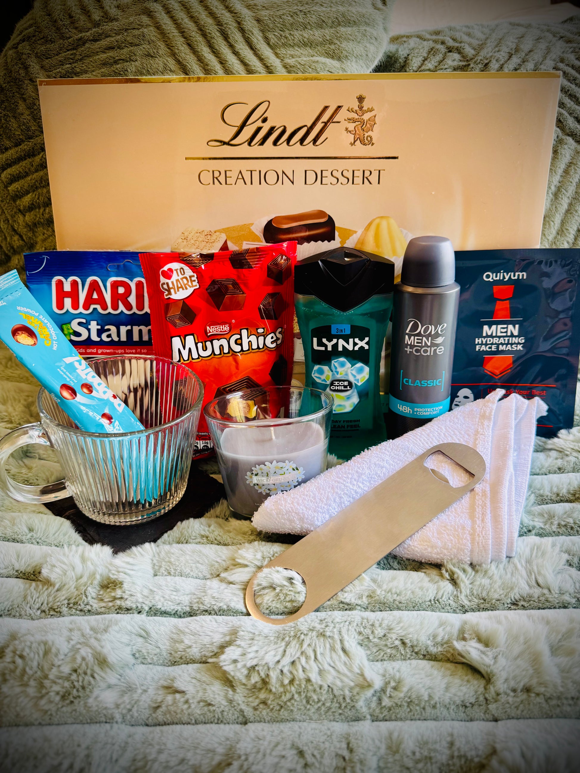 Assorted items including snacks, toiletries, and a candle birthday box with a handwritten card £50